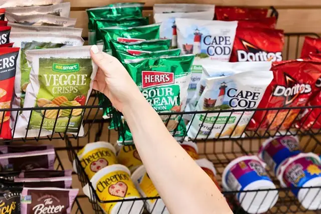 Hands reaching for bag of chips